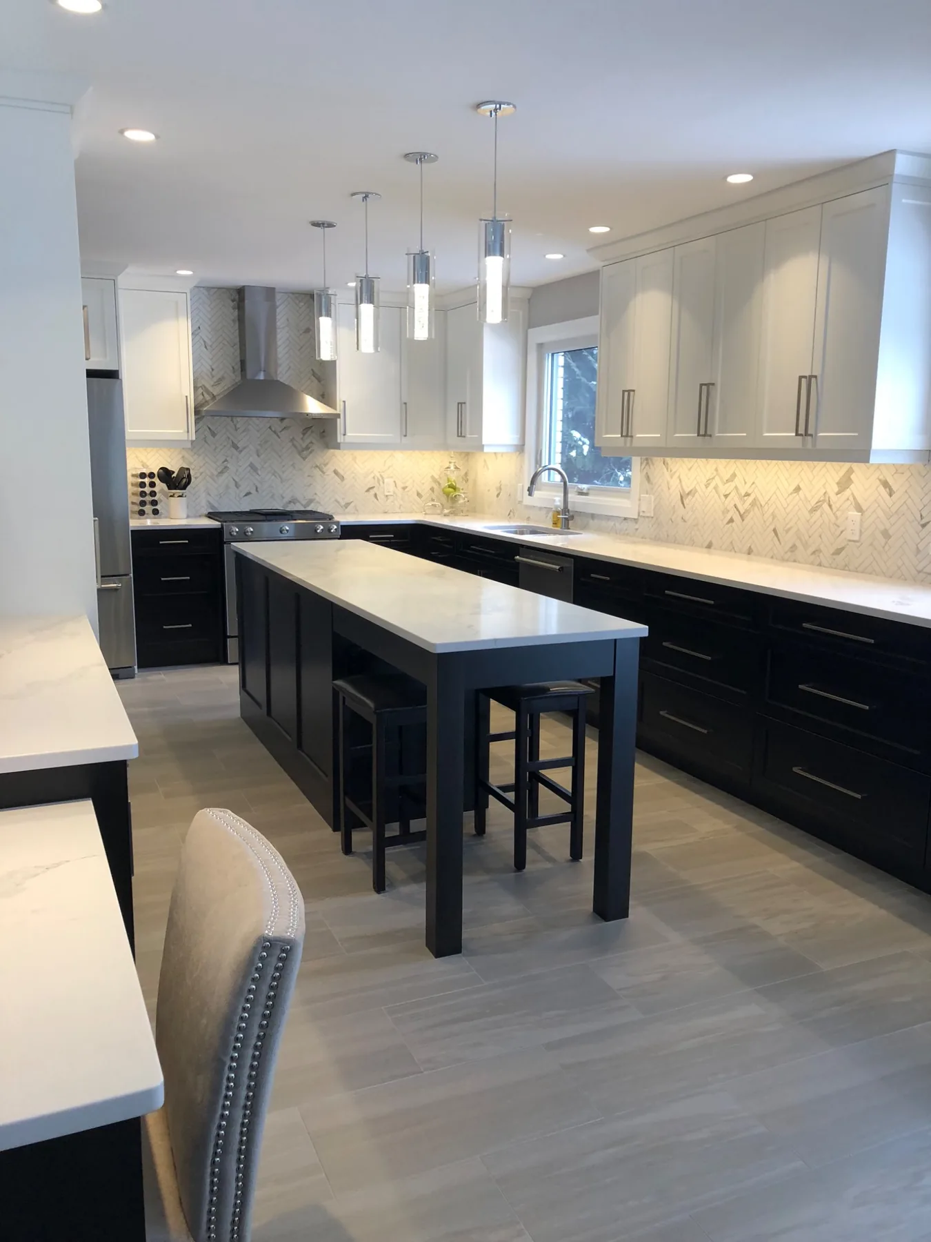 Two-tone kitchen with herringbone backsplash