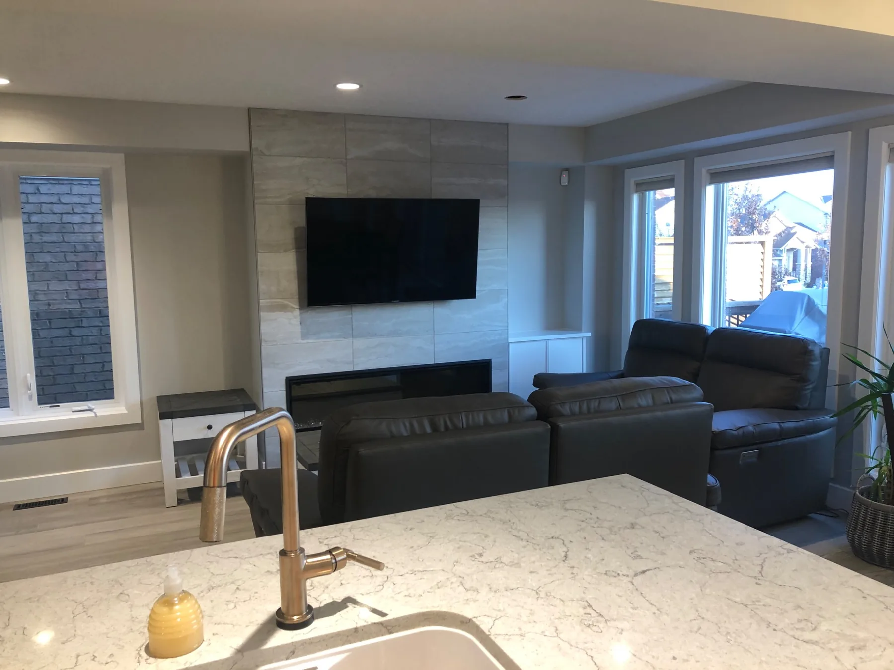 Open-concept living room with tiled fireplace wall